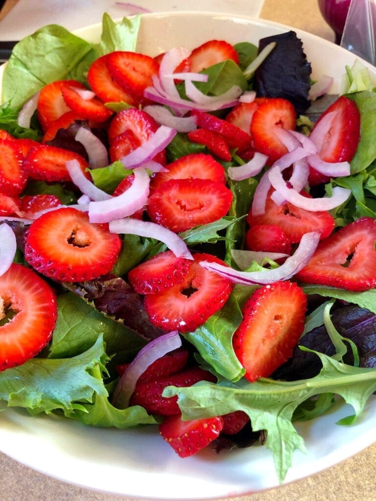 Adding Red Onion to the Salad Greens