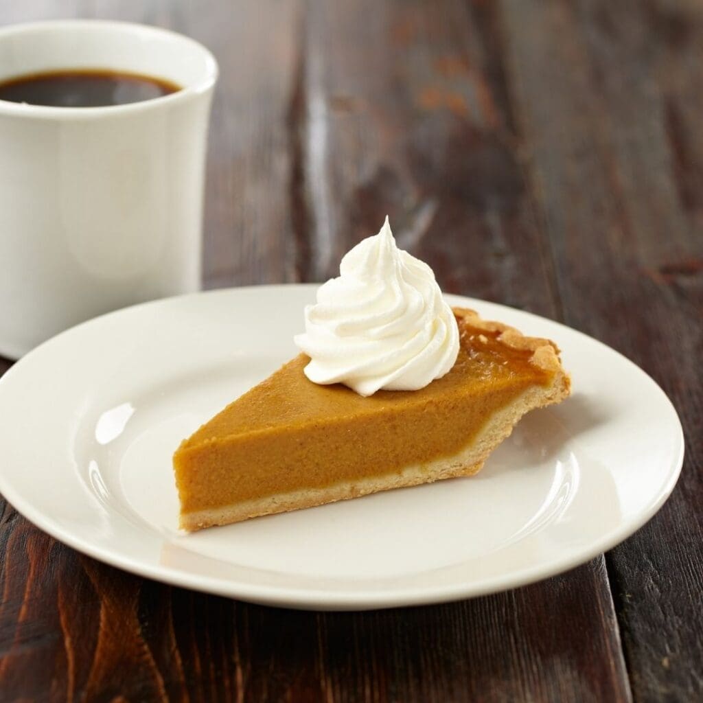 Slice of Pie with Whipped Topping and Cup of Coffee