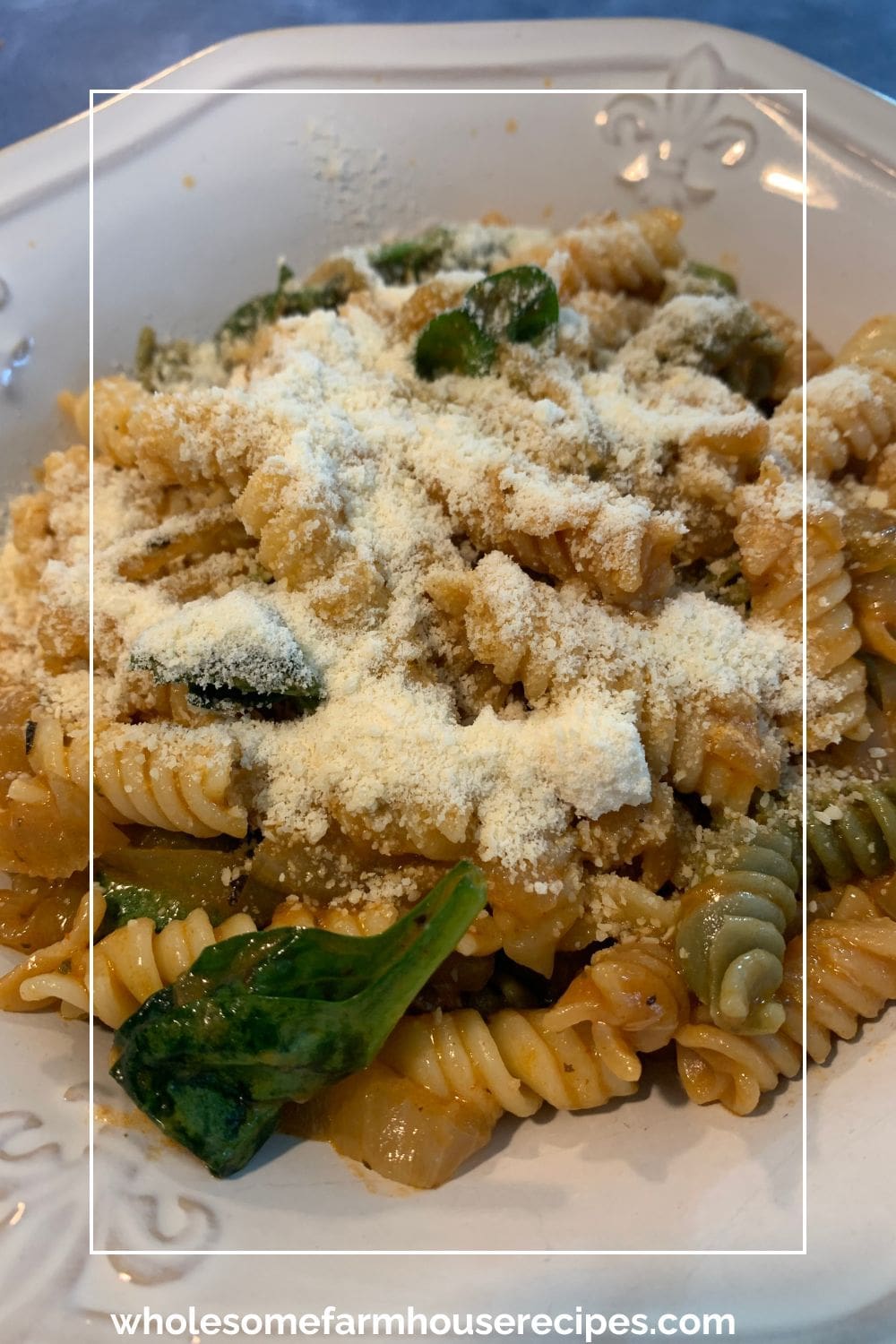 Bowl of Rigatoni spinach onions and parmesan cheese