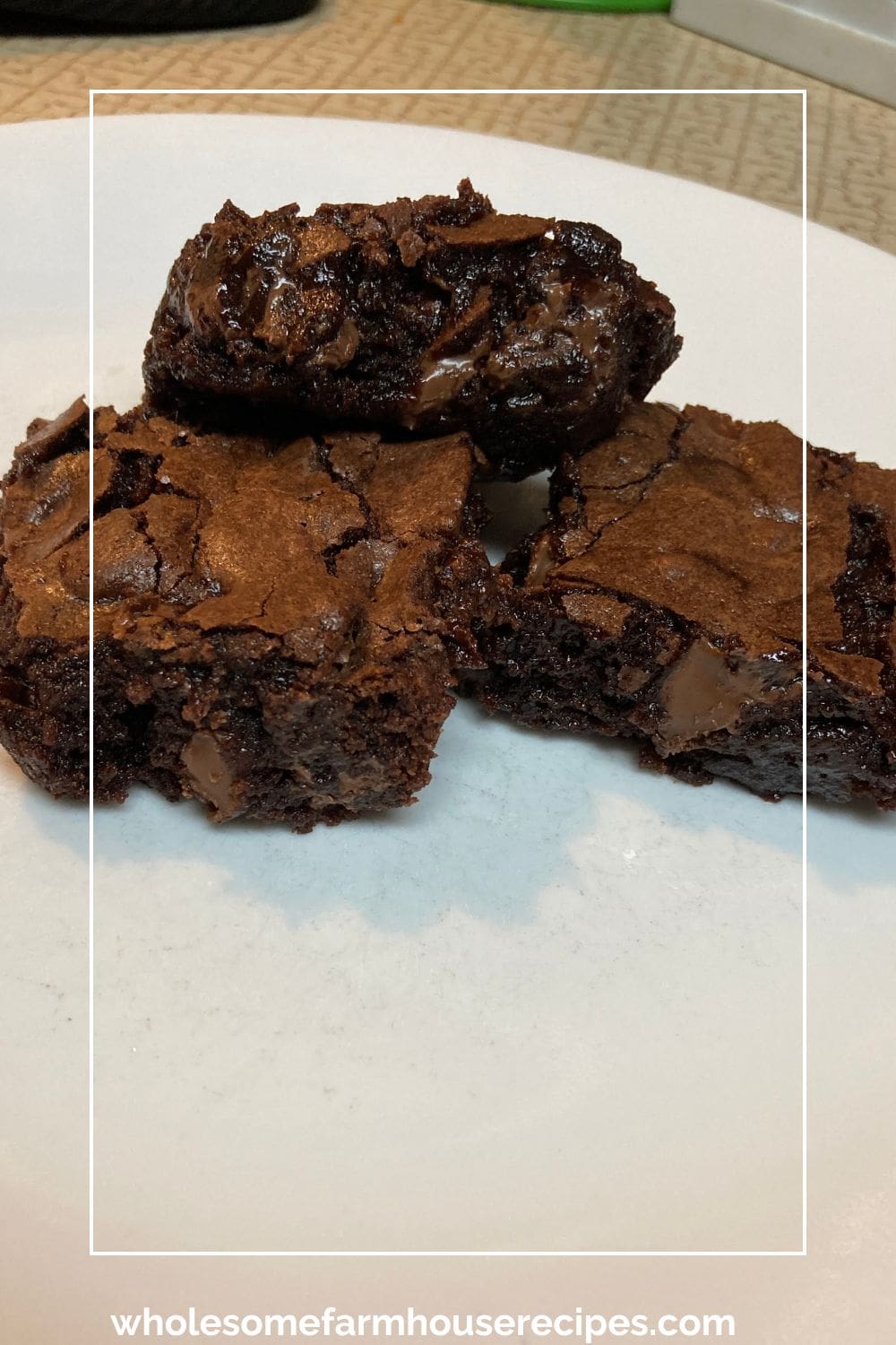 Three gooey brownies on a plate